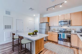 A kitchen with wooden cabinets and a white island.